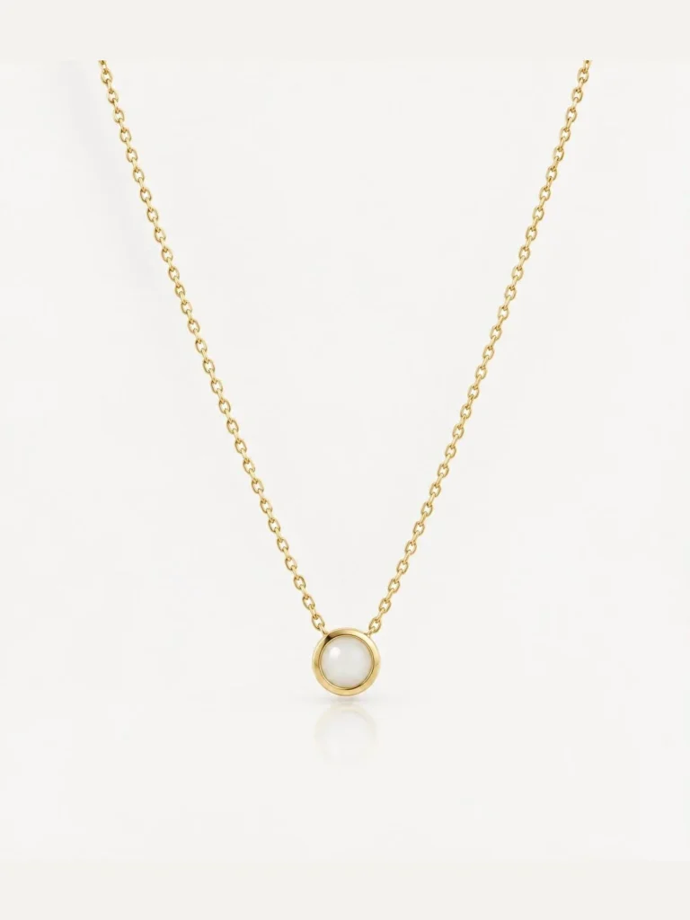 Breast milk keepsake pendant with a round milk stone in a gold bezel on a fine chain