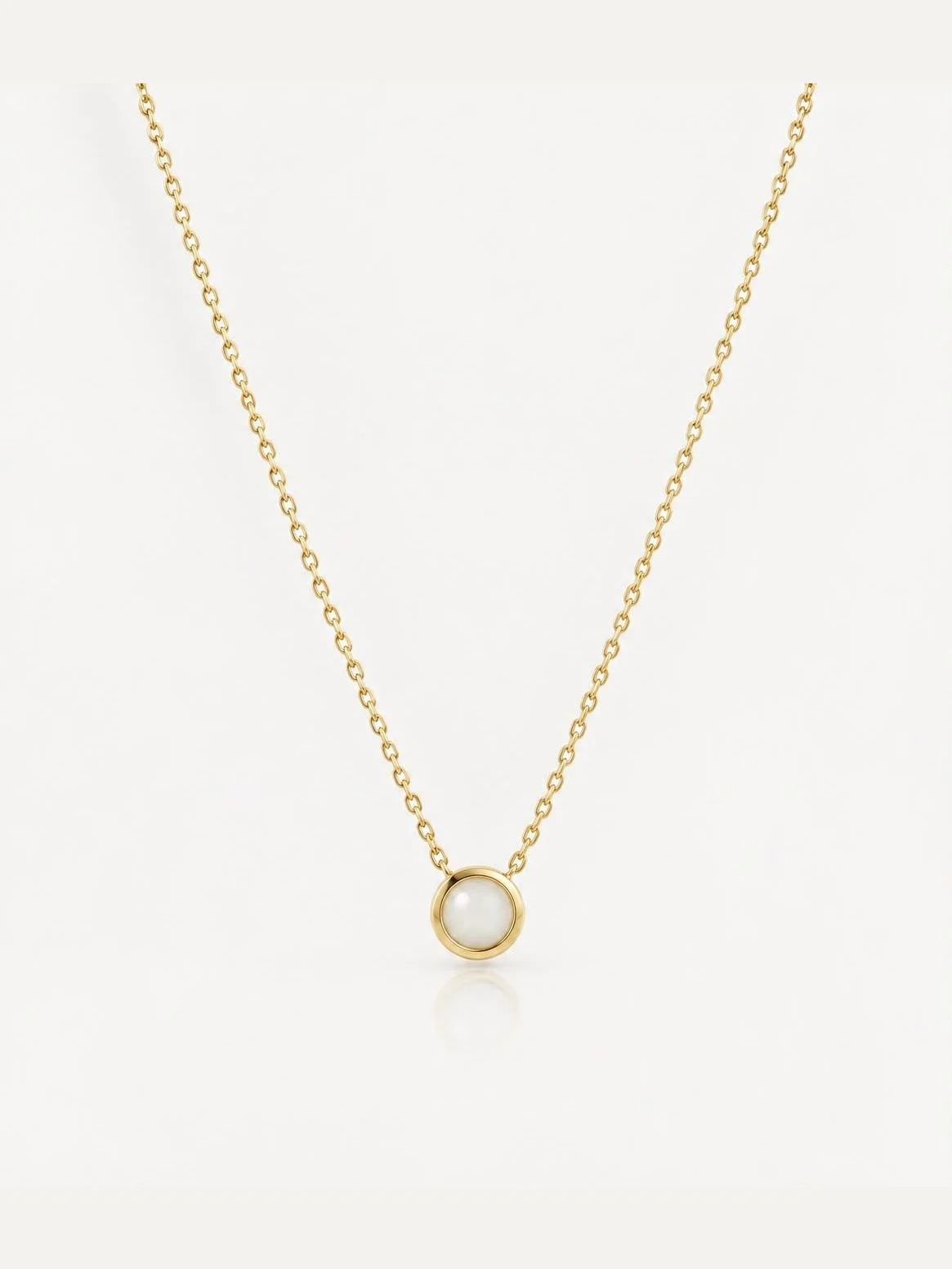 Breast milk keepsake pendant with a round milk stone in a gold bezel on a fine chain