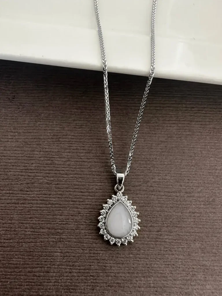 Breast milk keepsake pendant with a pear-shaped milk stone in a diamond halo on a white gold chain