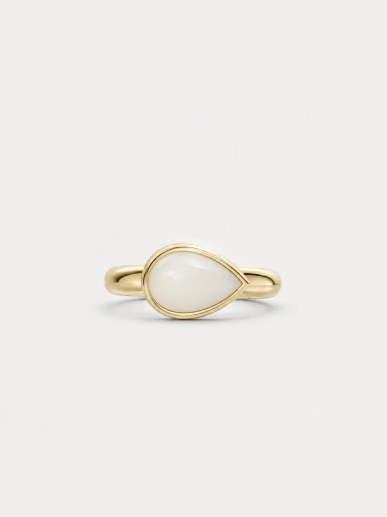 Breast milk keepsake ring with a pear-shaped milk stone set sideways in yellow gold