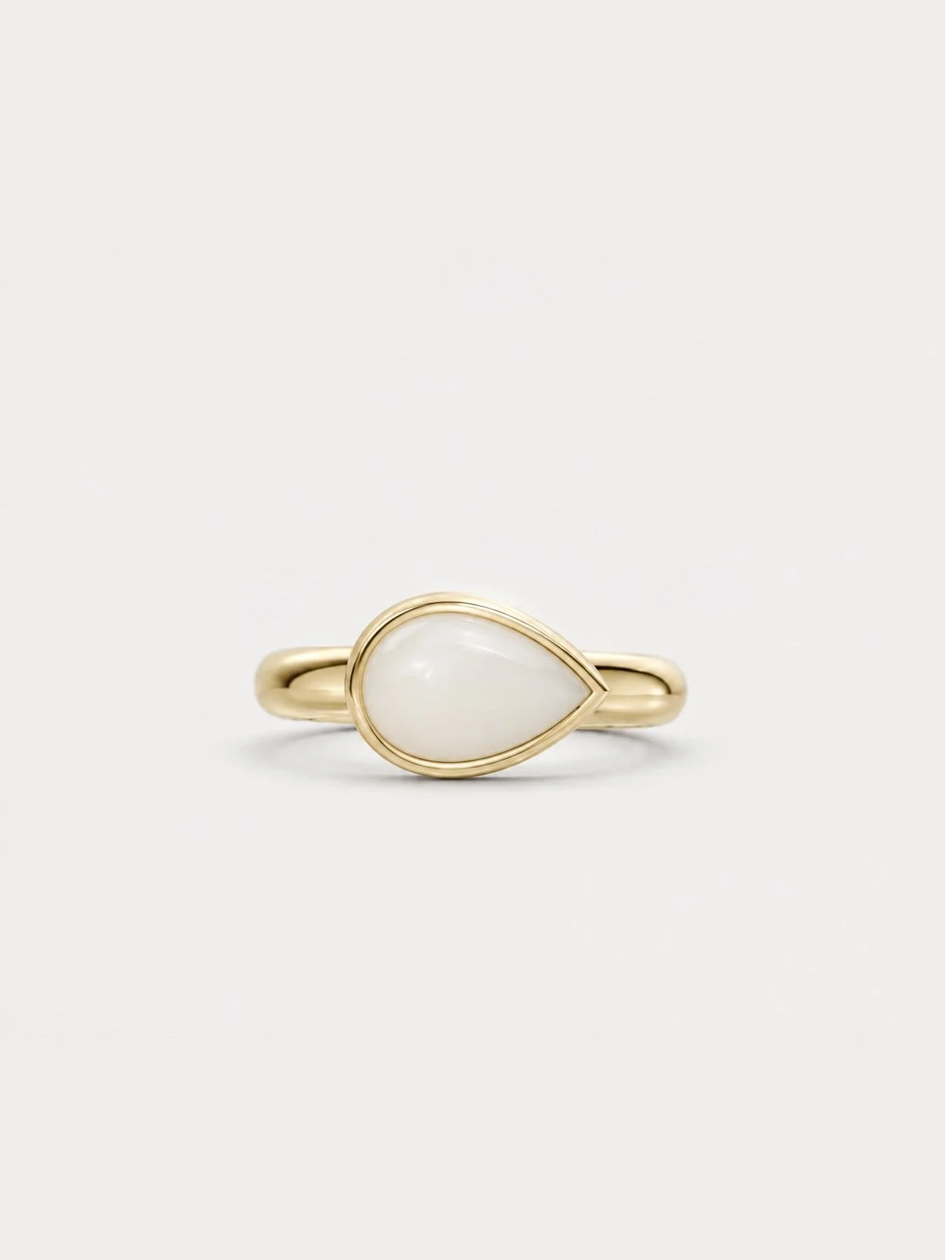 Breast milk keepsake ring with a pear-shaped milk stone set sideways in yellow gold