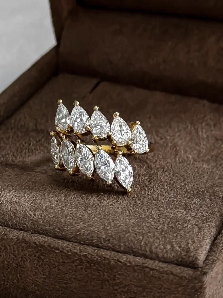 Gold bypass ring set with a row of pear diamonds crossing a row of marquise diamonds